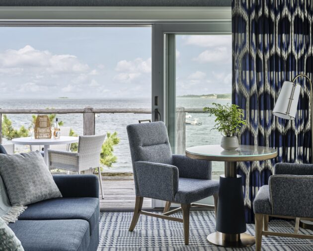 Scenic water view from a private balcony at Wequassett Resort, featuring outdoor dining furniture and a comfortable sitting area with patterned throw pillows.