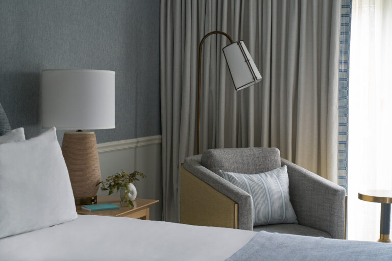 Inviting corner with plush chair, soft light, and serene tones.