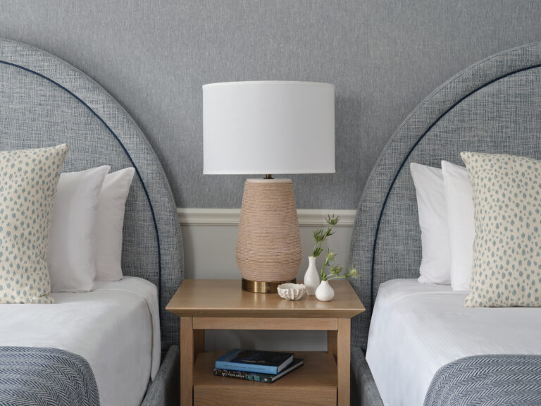 Two Queen beds with coastal accents and a soft glow lamp