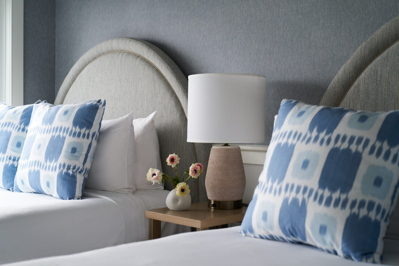 Serene guest room with plush beds and gentle, natural light.