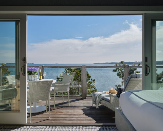Private balcony with sweeping waterfront views and cozy lounge area.