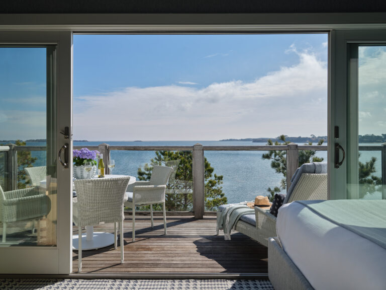 Private balcony with sweeping waterfront views and cozy lounge area.