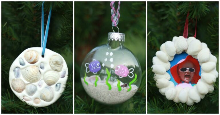 Three handmade ornaments hang on a Christmas tree in Mrs. Claus's Cottage: a shell-covered disc, a clear ornament with painted fish and sand, and a shell frame with a photo of a child in sunglasses and a red hat.