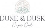 Logo for "Dune & Dusk Cape Cod" featuring a floral illustration and circular wood grain design above the text, perfect for the Merry Market or any festive annual event.