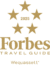 Gold Forbes Travel Guide 2025 logo with five stars above the text "Forbes Travel Guide" and "Wequassett Resort" written below, reflecting the luxury of this renowned resort and golf club.