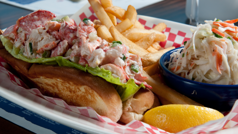cold lobster roll with fires and coleslaw on lunch tray