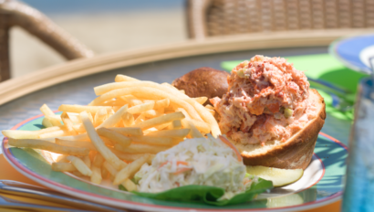 lobster roll and fries on plate outdoor patio table