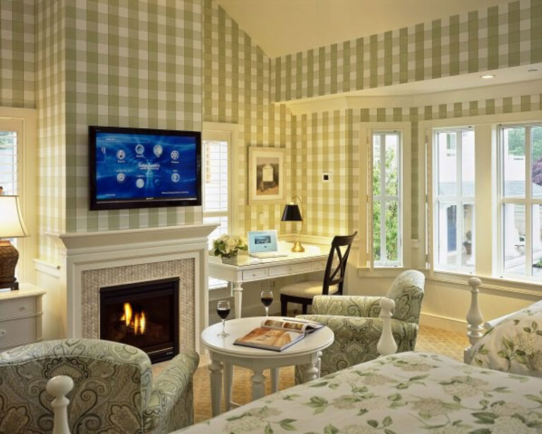 Hotel room on Cape Cod with yellow wallpaper and a white fireplace.