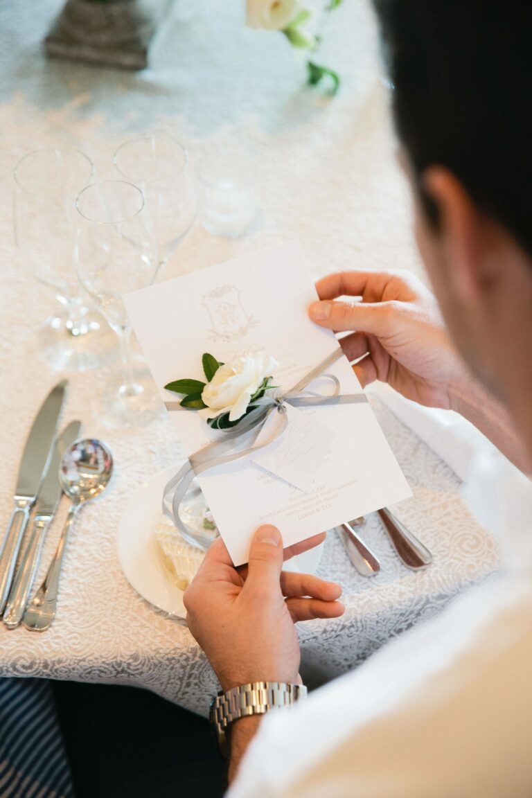 Man at place setting holding card.