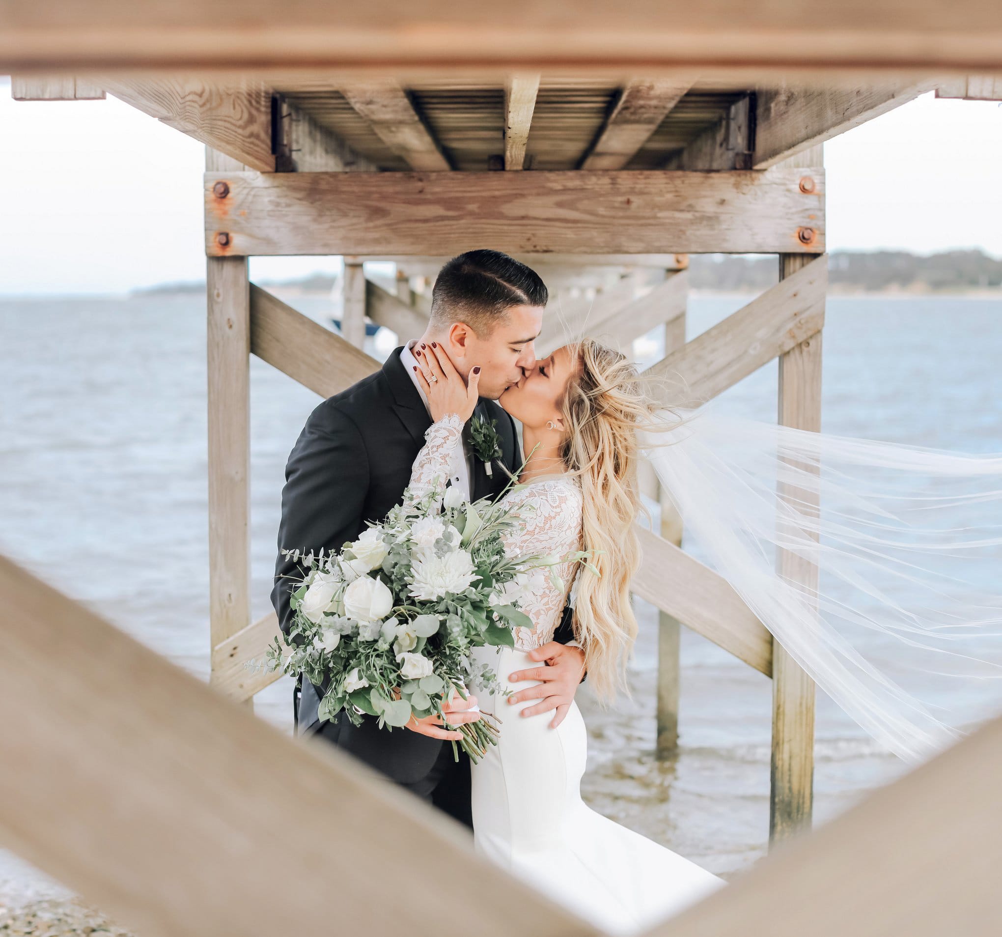 A couple kissing by the water.