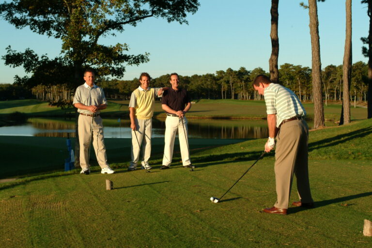 Four men playing golf.
