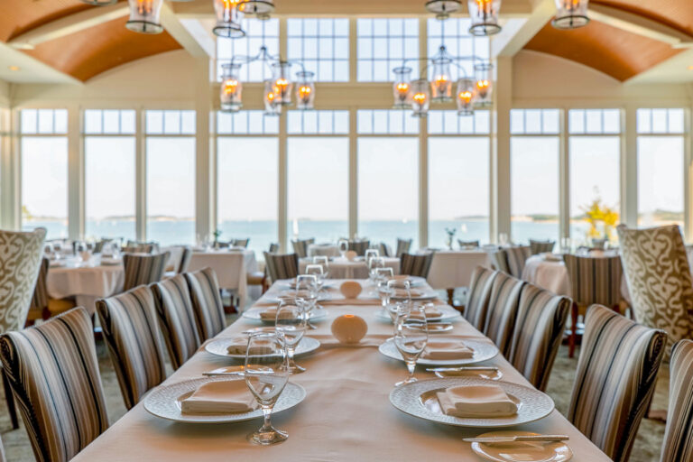 Tables set with ocean view at a fine dining restaurant on Cape Cod.