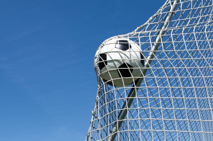 A soccer ball caught in the upper corner of a goal net against a clear blue sky captures the excitement of a summer of soccer at Wequassett.
