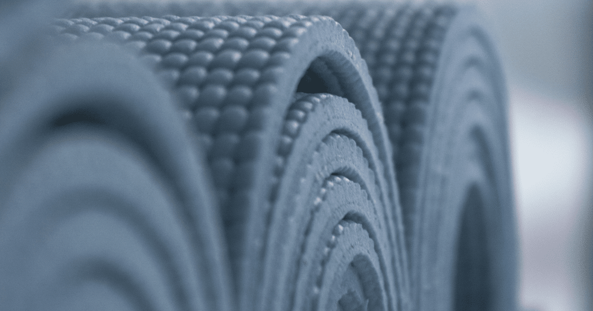 Close-up of several rolled-up textured yoga mats arranged side by side.